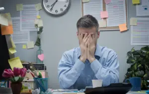 tired office worker with head in hands