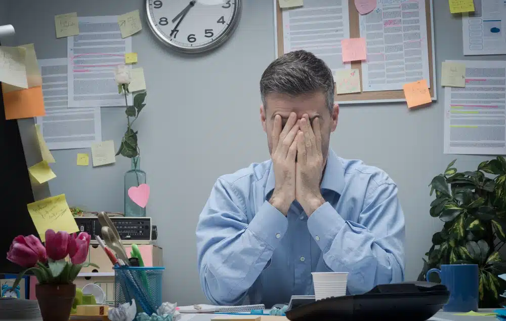 tired office worker with head in hands