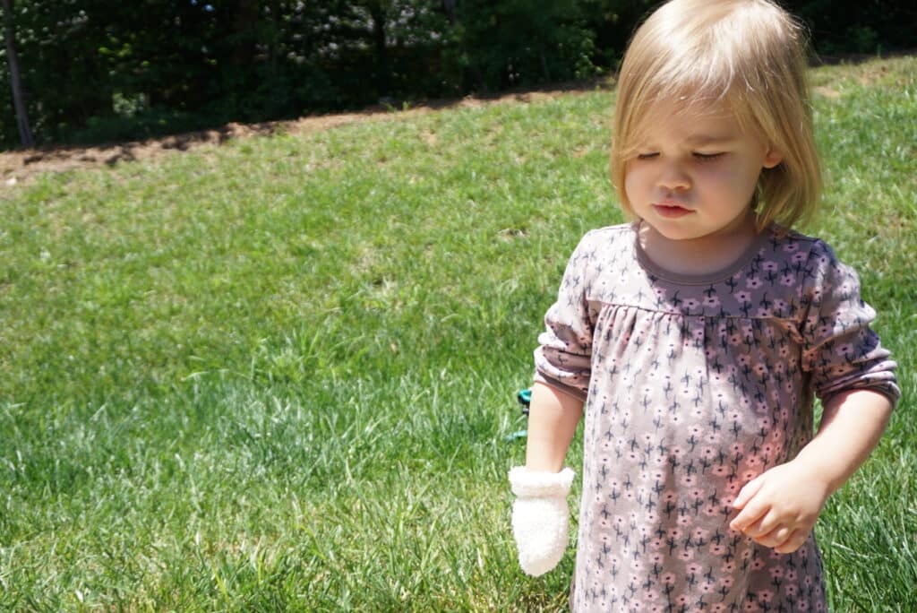 Indie wearing a mitten in June