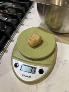 37g ball of tortilla dough sitting on a kitchen scale