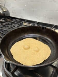 tortilla cooking in a cast iron skillet