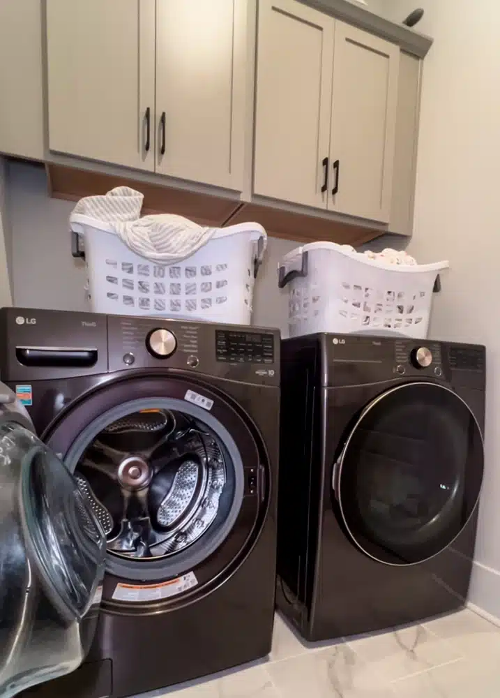 LG washing machine and dryer with full laundry baskets on top