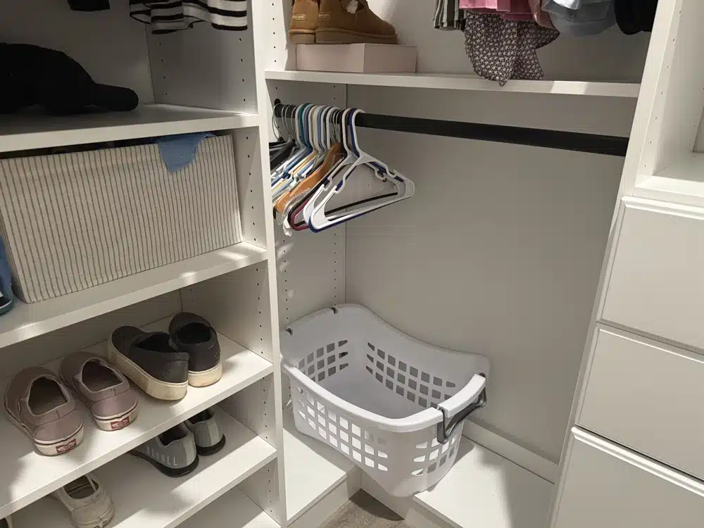 single laundry basket on bottom shelf in walk-in closet