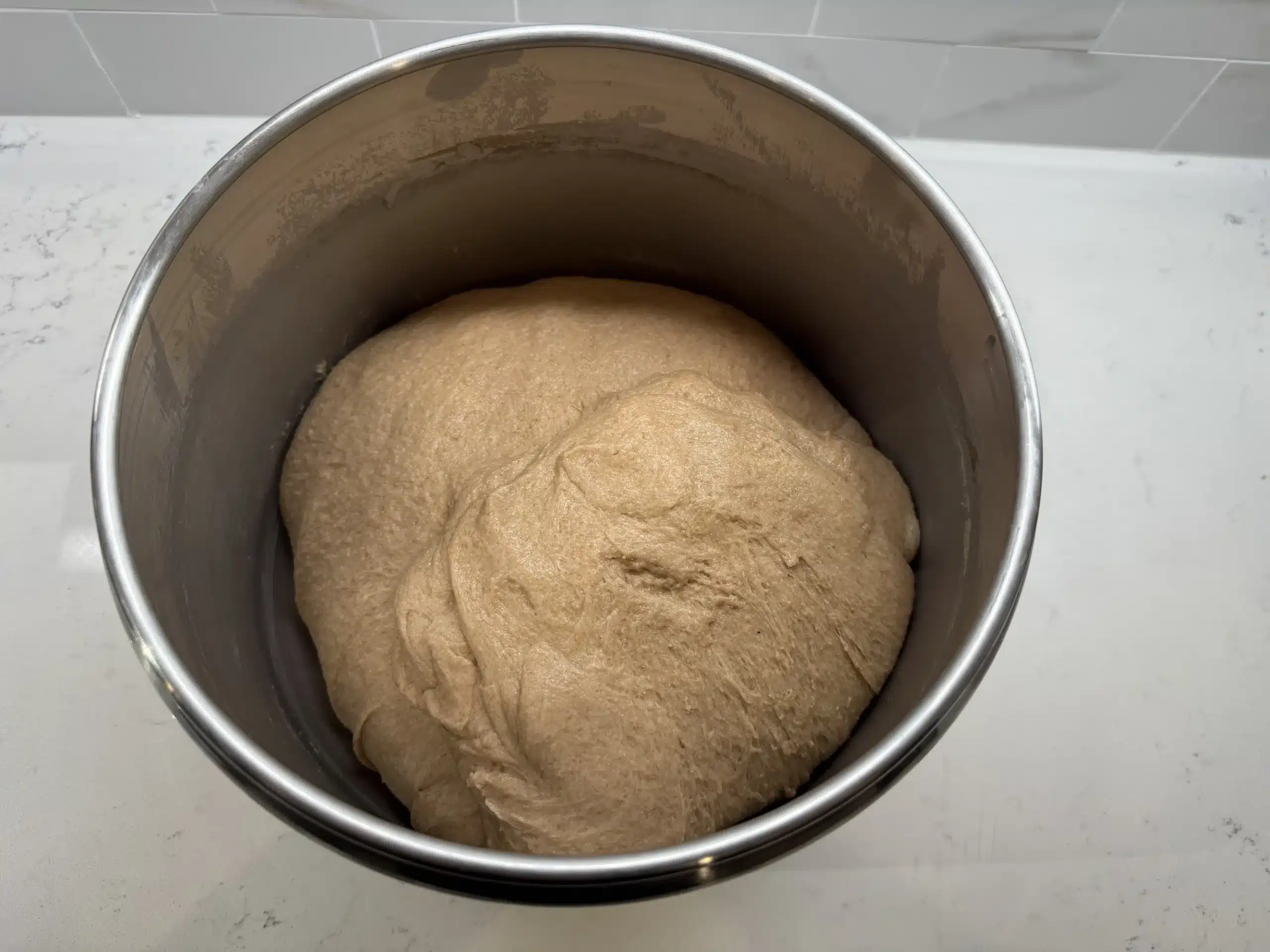 Overhead shot of sourdough sandwich bread dough in large mixer bowl