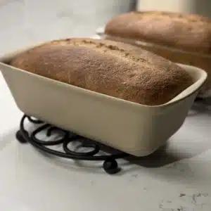 Side angle shot of baked sourdough sandwich bread in stone loaf pan